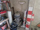 un tas d'ordures dans une pièce, avec un balai et une serpillière
