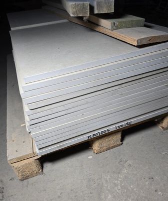 a stack of metal plates on a pallet in a warehouse