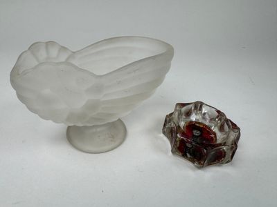 un petit bol en verre et un autre petit bol en verre posés sur une surface blanche