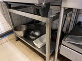une étagère métallique avec des casseroles et des poêles dans une cuisine