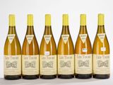 six bouteilles de vin sont alignées sur une surface blanche