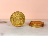 a gold coin sitting next to a stack of gold coins