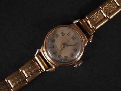an image of a gold wrist watch on a black background