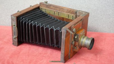 un vieil appareil photo en bois muni d'un objectif