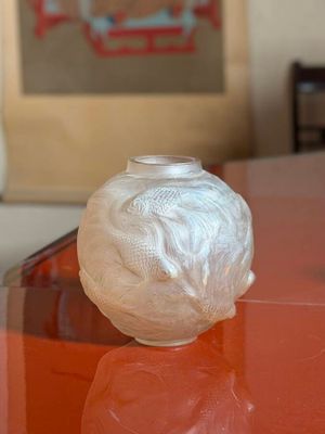 a white vase sitting on top of a red table