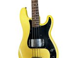 yellow electric bass guitar on a stand against a white background