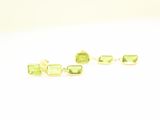 une paire de boucles d'oreilles en tourmaline verte posées sur un fond blanc