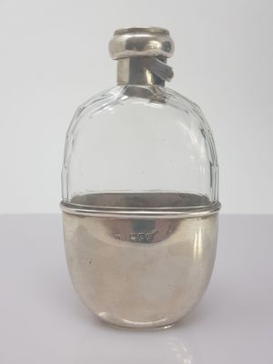 a small glass bottle with a silver lid on a table