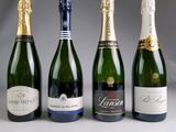 four bottles of champagne are lined up in a row
