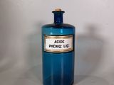 une bouteille bleue avec une étiquette, posée sur une table