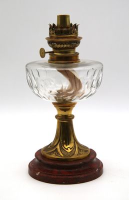 une lampe à l'ancienne avec un abat-jour en verre posé sur un socle en bois
