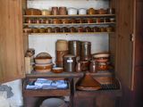 many pots and pans on the shelves in this kitchen