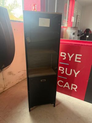 a black refrigerator next to a red and white sign
