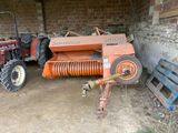 a tractor that is parked next to a hay bale