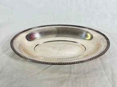 a close up of a silver plate on a white cloth