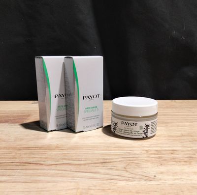 un gros plan sur une boîte et un pot de crème pour le visage posés sur une table