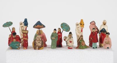 many figurines of people with umbrellas on a white surface