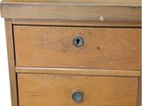 a small wooden table with two drawers on it