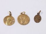 three gold coin pendants, one of which is a woman and one of which is a man