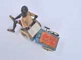 a figurine of a man sitting in a cart with a pizza on it
