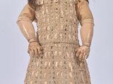 an image of a doll with a hat and dress on