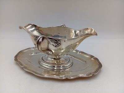 un service en argent ancien composé d'une assiette et d'une soucoupe posée dessus