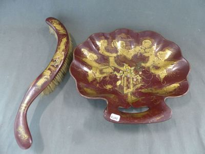 un bol rouge et doré et une banane posés sur une table