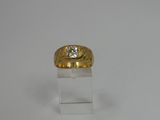 yellow gold ring with a diamond on top of a clear acrylic stand