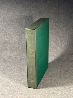 an old green book sitting on top of a gray surface