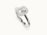 gros plan d'une bague en diamant et émeraude sur fond blanc