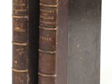 two old books sitting on top of each other on a white surface