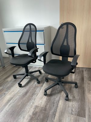 deux chaises de bureau noires placées l'une à côté de l'autre sur un parquet