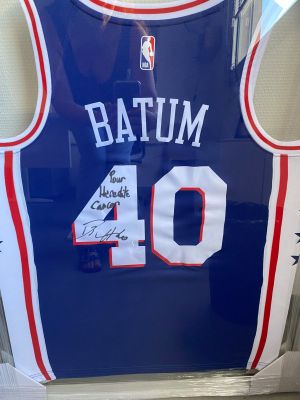 Un maillot bleu portant le numéro 40 est accroché au mur.
