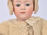 a doll that is wearing a sweater and a hat