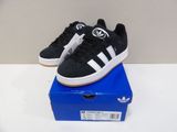 black and white adidas sneakers on a blue box on a white table
