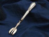 a silver spoon and fork sitting on a blue cloth