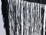 a close up of a black shawl with fringes hanging from it