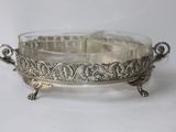 an antique silver plate with a bird on it on a white surface