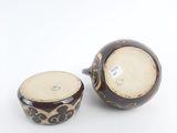 pair of brown and white vases sitting on top of a white surface
