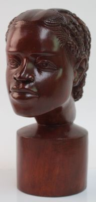 sculpture marron représentant la tête d'une femme, posée sur un socle en bois