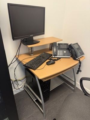 un bureau sur lequel se trouvent un ordinateur et un téléphone