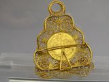 une pièce d'or sur laquelle est représenté un avion, exposée dans une vitrine
