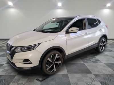 un SUV Nissan blanc garé sur un sol à damier dans un parking