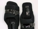 pair of black slippers with buckles on a white surface