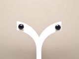 pair of black and white diamond stud earrings on a white stand