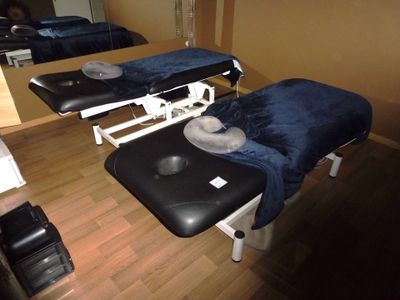 deux tables de massage dans une pièce où il y a un miroir accroché au mur