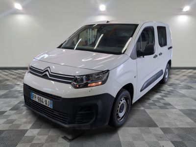 la camionnette blanche est garée sur un sol en damier dans le garage