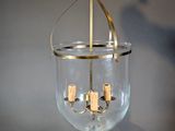 a glass hanging light with corks inside of it