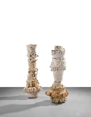 deux vases blancs posés l'un à côté de l'autre sur une table