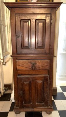 une grande armoire en bois au milieu d'un sol carrelé